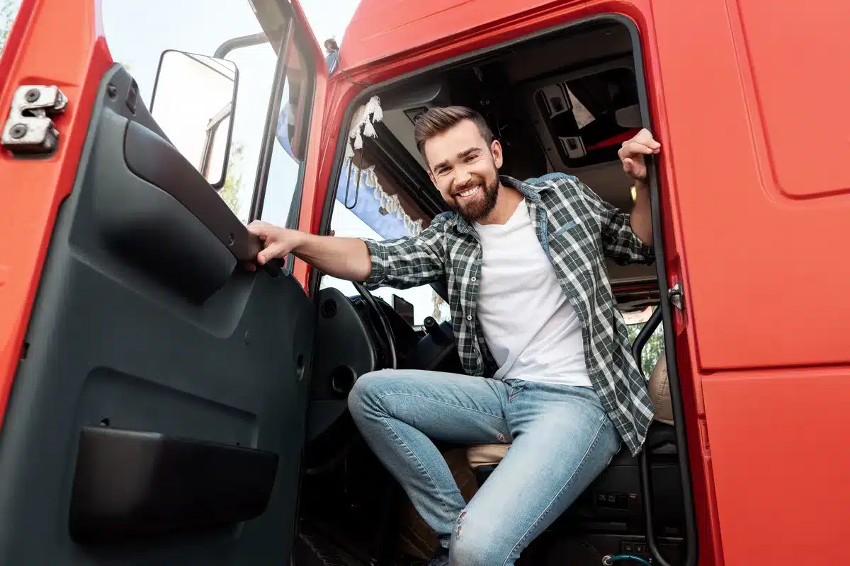 young-smiling-male-truck-driver-inside